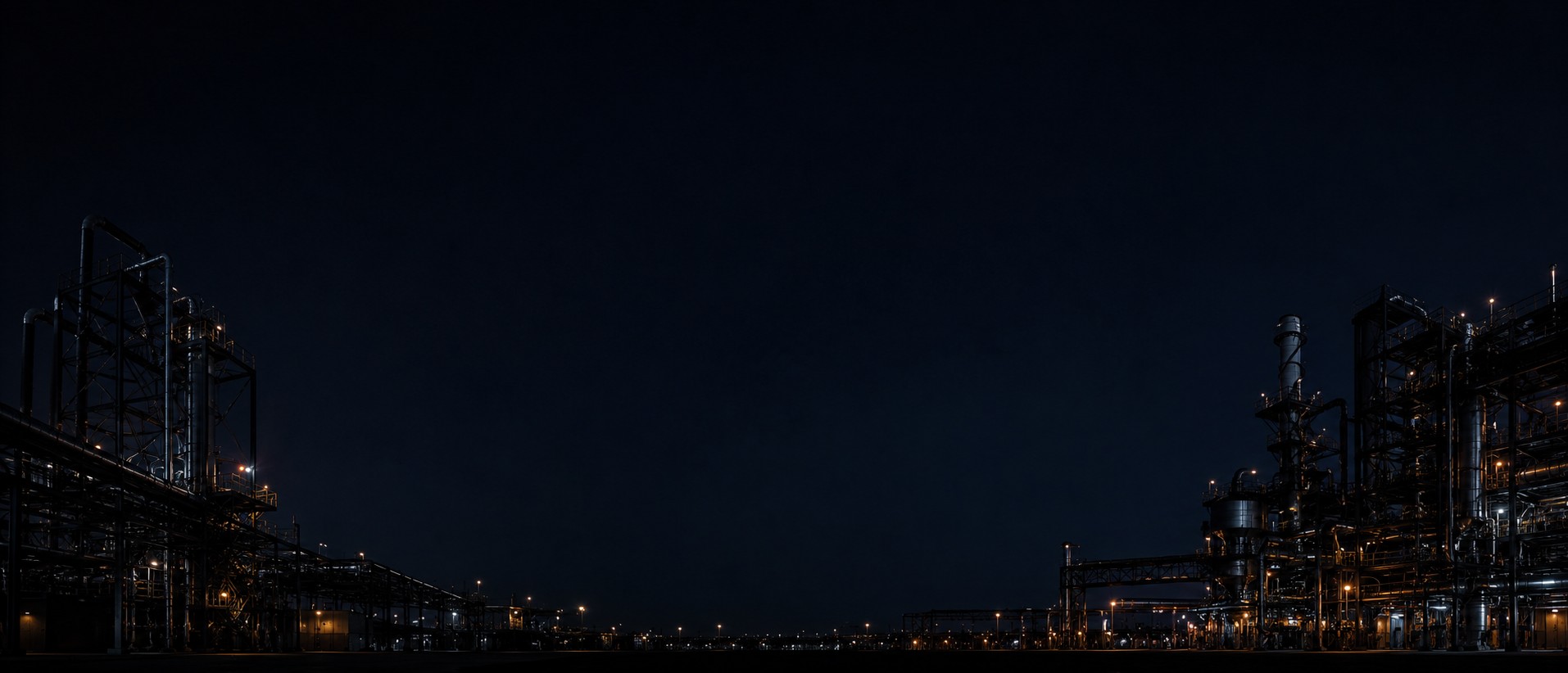 Industrial facility silhouetted against a deep night sky with scattered service lights